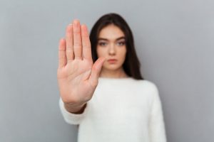 Close up portrait of a woman showing stop gesture